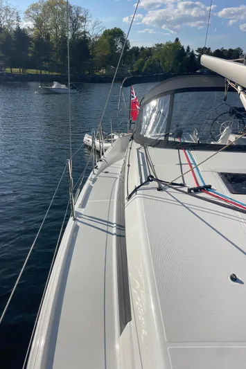  Yacht Photos Pics 2024 Jeanneau Sun Odyssey 380 sailboat on calm water, showcasing sleek deck design.