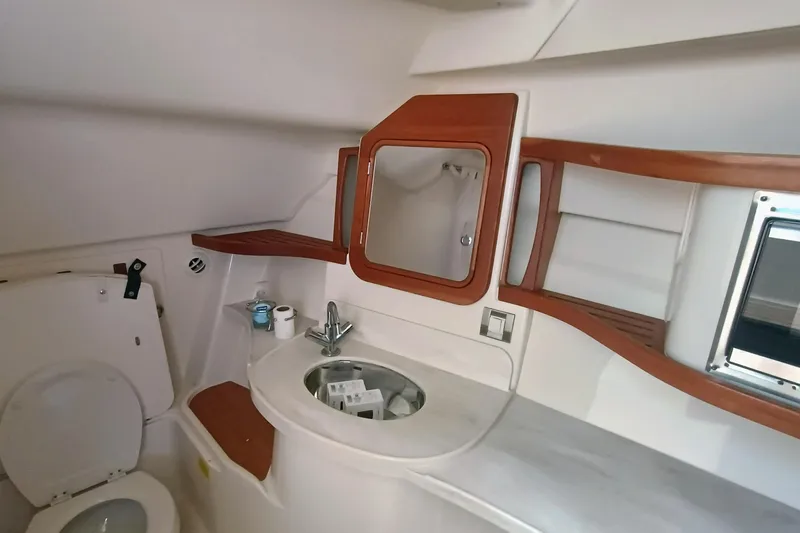 375-712 Used Yacht Photos Pics 2021 Grady-White Freedom 375 boat bathroom with sink, mirror, and wooden accents.