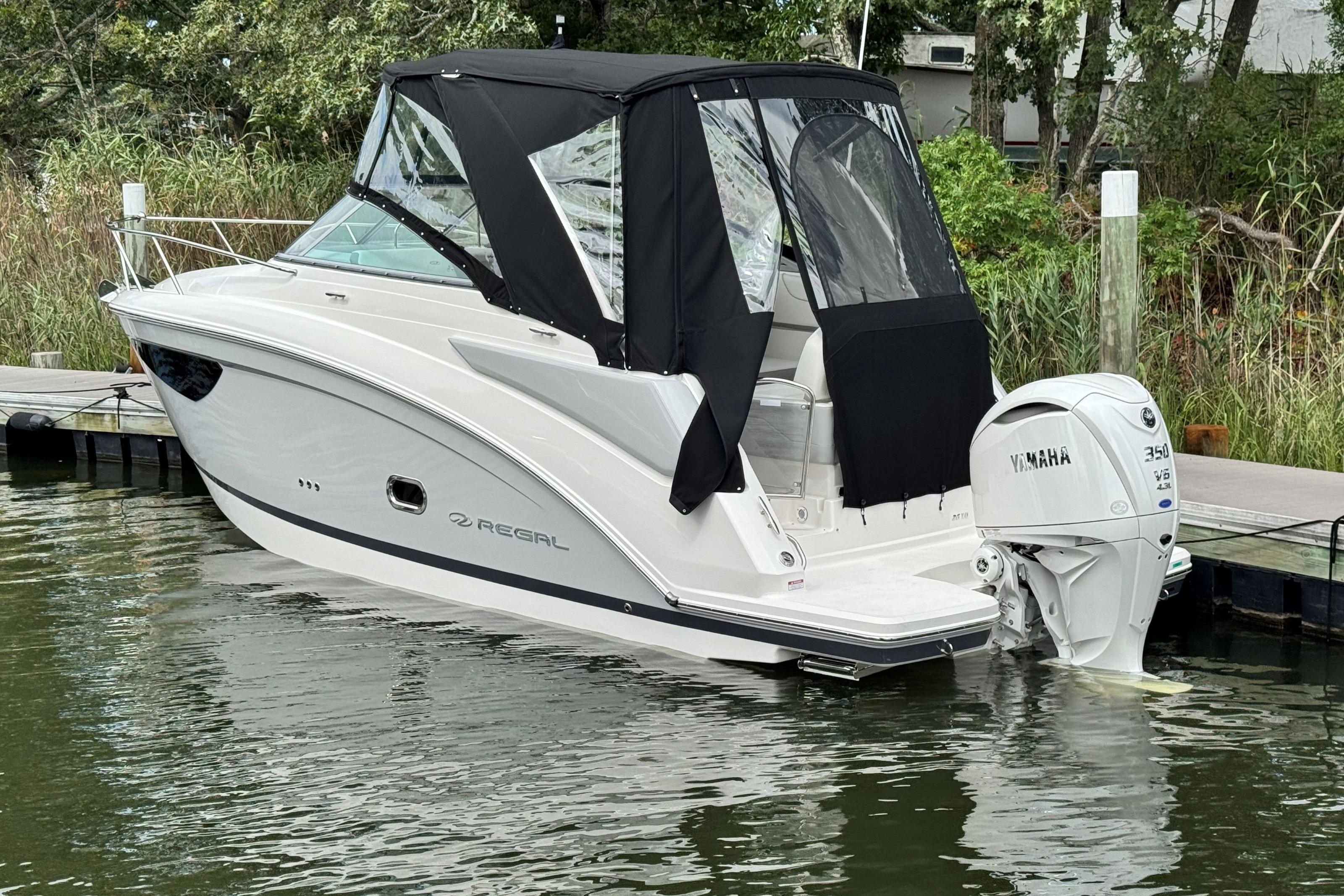 2026 Regal 26 XO boat docked with Yamaha 350 engine, featuring black canopy.
