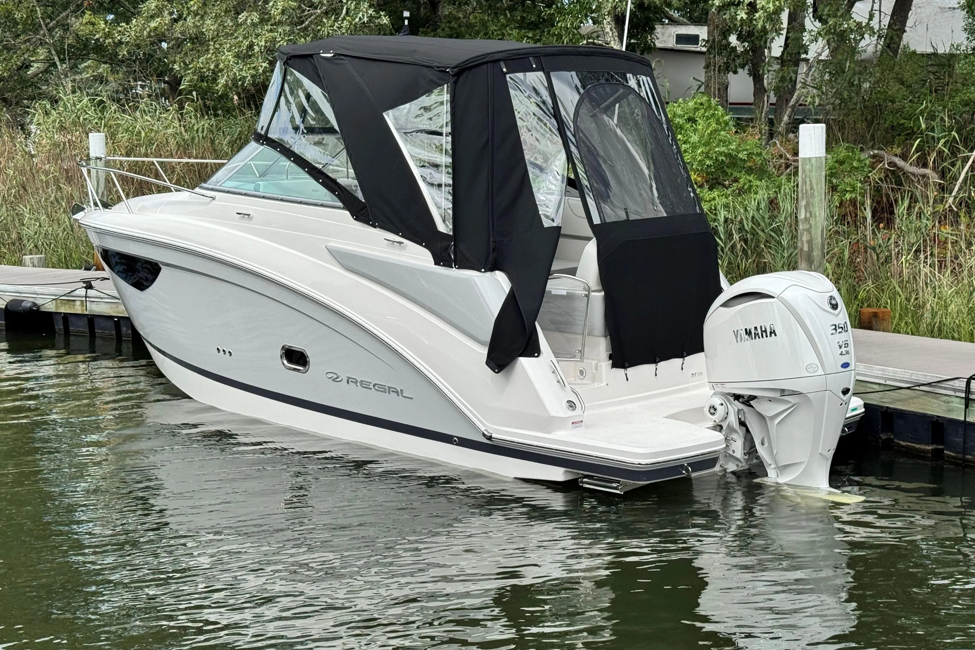 2026 Regal 26 XO boat docked with Yamaha 350 engine, featuring black canopy.