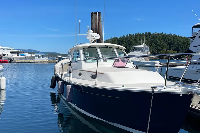 Tui Yacht Photos Pics 2005 Back Cove 29 boat docked in a marina, surrounded by calm water and other vessels.