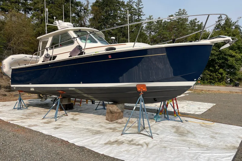 Tui Yacht Photos Pics 2005 Back Cove 29 boat on stands, blue hull, outdoor setting.