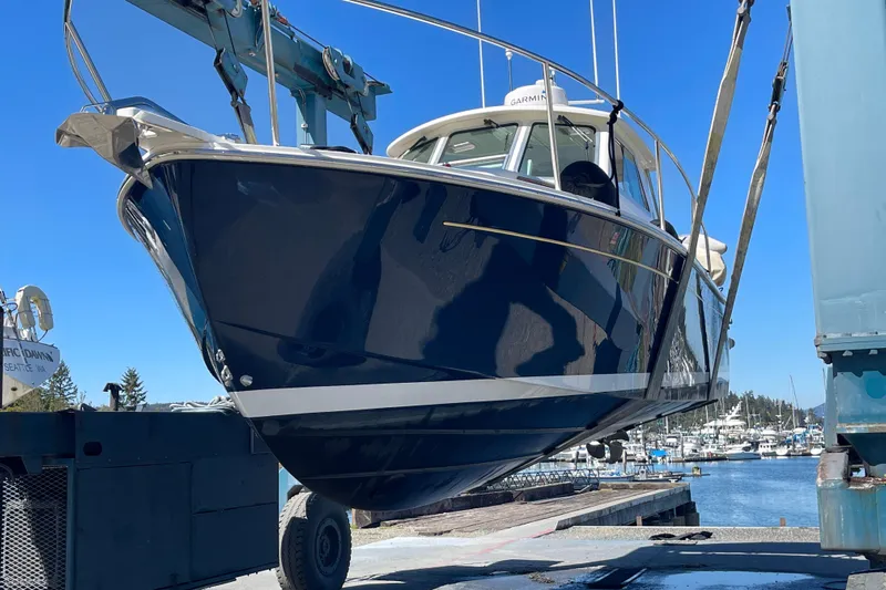 Tui Yacht Photos Pics 2005 Back Cove 29 boat being lifted at a marina under clear blue skies.