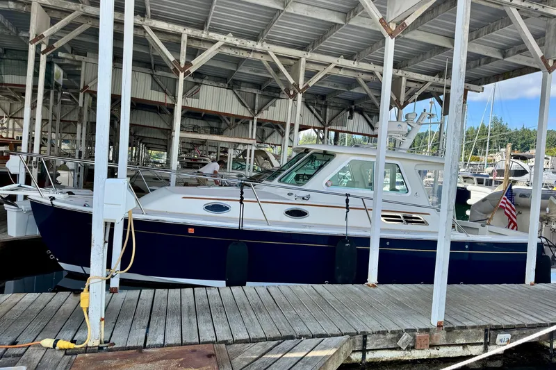 Tui Yacht Photos Pics 2005 Back Cove 29 boat docked in a covered marina, featuring a sleek design.