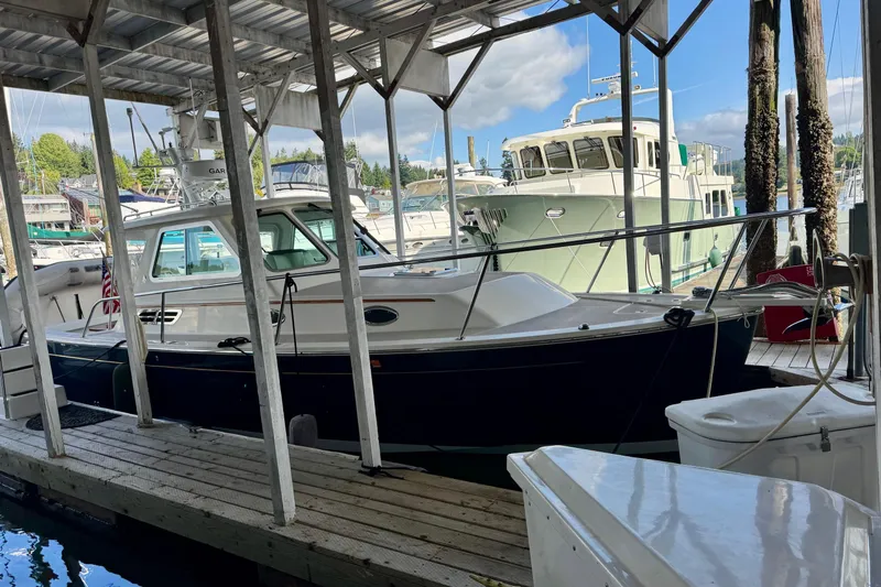 Tui Yacht Photos Pics 2005 Back Cove 29 boat docked in a marina under a covered shelter.