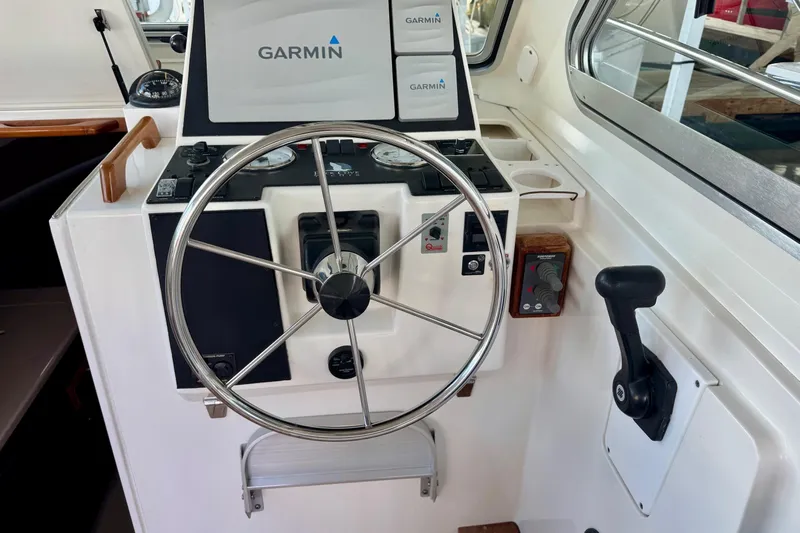 Tui Yacht Photos Pics 2005 Back Cove 29 helm with Garmin navigation, steering wheel, and control panel.