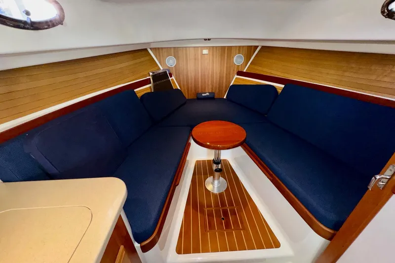 Tui Yacht Photos Pics Interior of 2005 Back Cove 29 boat with blue seating and wooden accents.