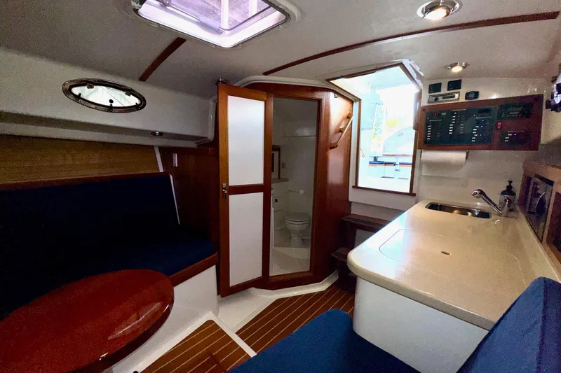 Tui Yacht Photos Pics 2005 Back Cove 29 interior with seating, kitchenette, and bathroom.