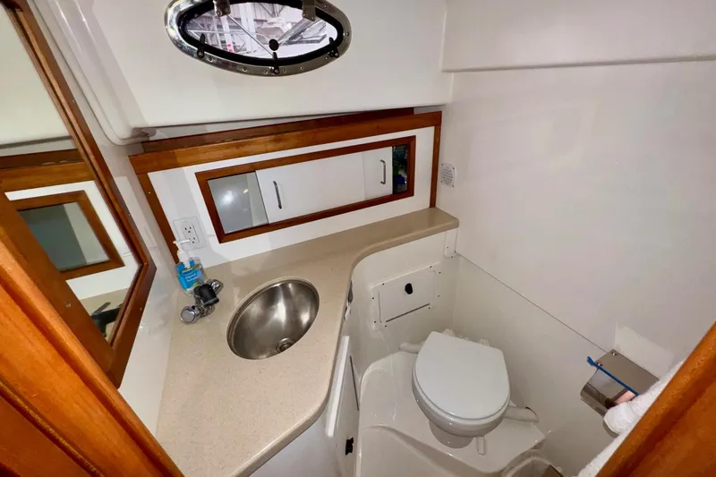Tui Yacht Photos Pics 2005 Back Cove 29 boat bathroom with sink, mirror, and toilet.
