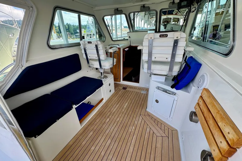 Tui Yacht Photos Pics Interior of a 2005 Back Cove 29 boat with seating and wooden flooring.