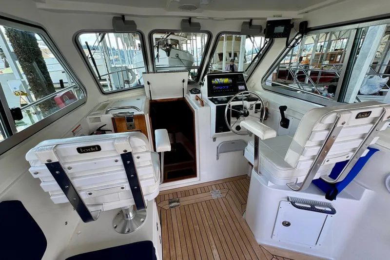 Tui Yacht Photos Pics 2005 Back Cove 29 boat interior with steering wheel and seating.