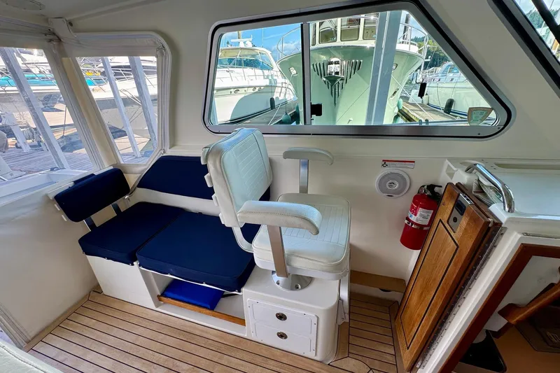 Tui Yacht Photos Pics Interior of a 2005 Back Cove 29 boat with seating and wooden flooring.