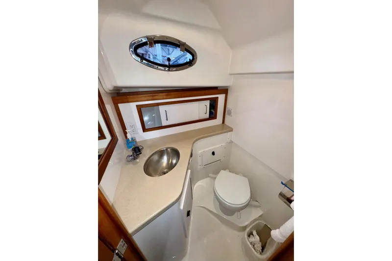 Tui Yacht Photos Pics 2005 Back Cove 29 boat bathroom with sink, toilet, and storage cabinet.