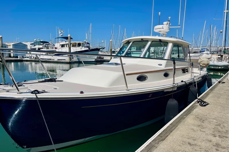 Tui Yacht Photos Pics 2005 Back Cove 29 boat docked in marina, clear blue sky, calm waters.