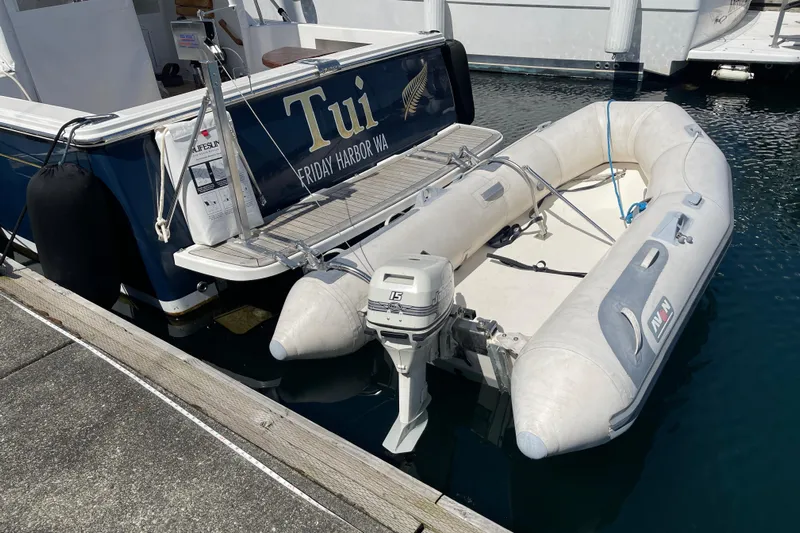 Tui Yacht Photos Pics 2005 Back Cove 29 boat docked with inflatable dinghy and outboard motor.
