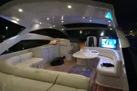 Luxurious 2010 Pershing 56 yacht interior with elegant seating, ambient lighting, and a TV.