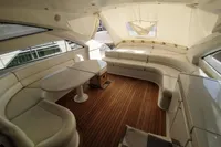 Luxurious interior of 2010 Pershing 56 yacht with elegant seating and wooden flooring.