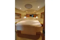 Luxurious bedroom interior of 2010 Pershing 56 yacht with elegant lighting and cozy bedding.
