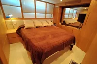Luxurious bedroom interior of 2010 Pershing 56 yacht with cozy bedding and modern design.