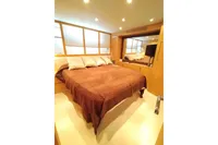 Luxurious bedroom interior of 2010 Pershing 56 yacht with cozy bedding and modern design.