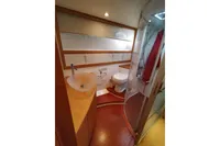 Luxurious bathroom in 2010 Pershing 56 yacht with modern fixtures and curved shower.