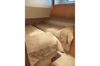 Twin beds in a cozy cabin of a 2010 Pershing 56 yacht.