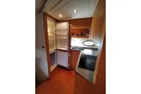 Compact kitchen in 2010 Pershing 56 yacht with open fridge and modern amenities.