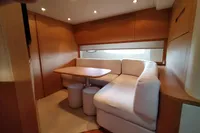 Luxurious interior of 2010 Pershing 56 yacht with cozy seating and wooden finishes.