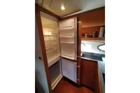 Open refrigerator in 2010 Pershing 56 yacht kitchen, showcasing interior shelves and modern design.