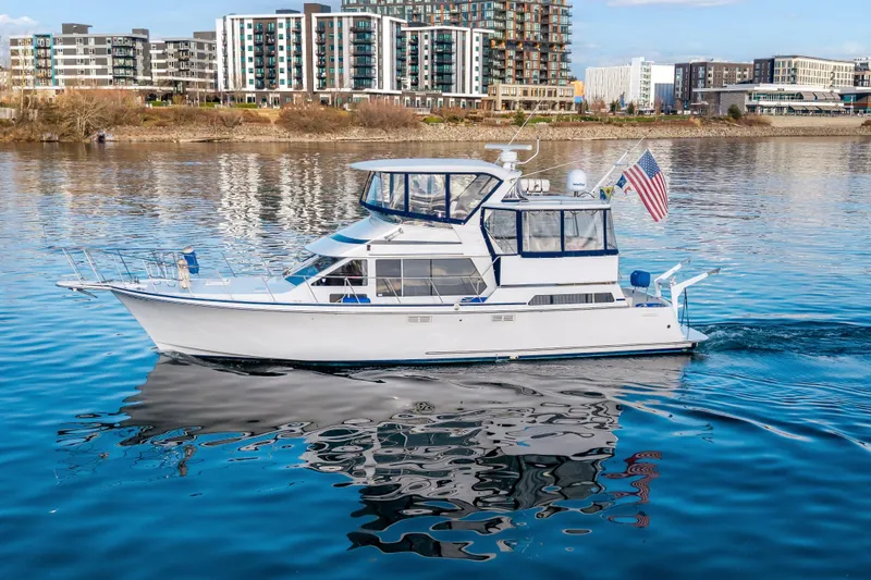  Yacht Photos Pics 1994 Tollycraft 45 Cockpit Motor Yacht cruising on calm waters near urban skyline.