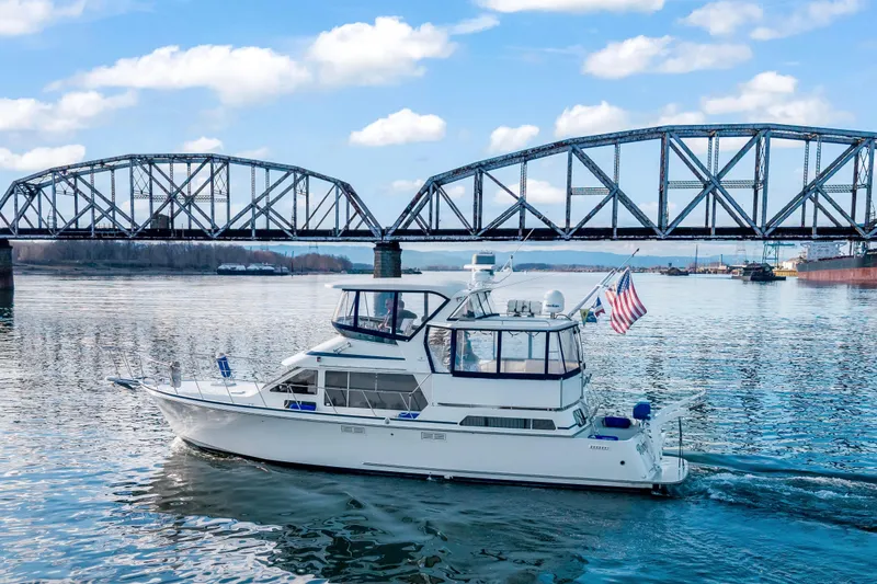  Yacht Photos Pics 1994 Tollycraft 45 Cockpit Motor Yacht cruising under a steel bridge on a sunny day.
