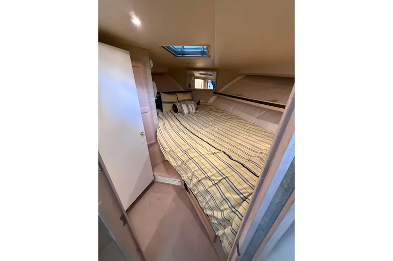  Yacht Photos Pics 1994 Tollycraft 45 Cockpit Motor Yacht cabin with striped bedding and skylight.