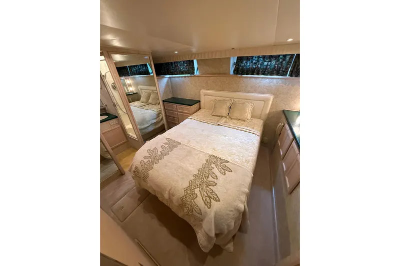  Yacht Photos Pics Luxurious bedroom in 1994 Tollycraft 45 Cockpit Motor Yacht with elegant bedding and mirrored closet.