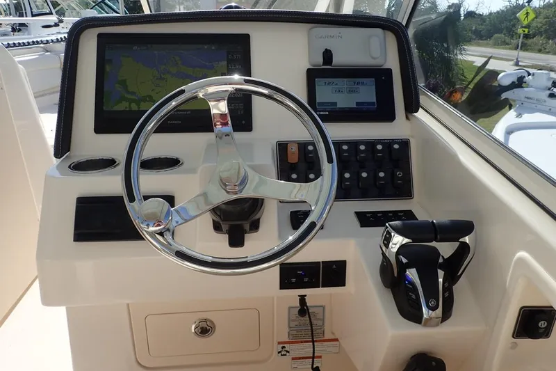  Yacht Photos Pics 2021 Grady-White Freedom 285 boat dashboard with steering wheel and navigation controls.
