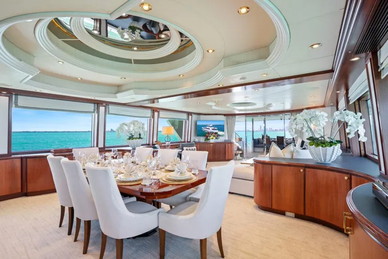 Risk And Reward Yacht Photos Pics Luxurious Crescent Raised Pilothouse yacht interior with elegant dining area, panoramic ocean views, and modern decor.