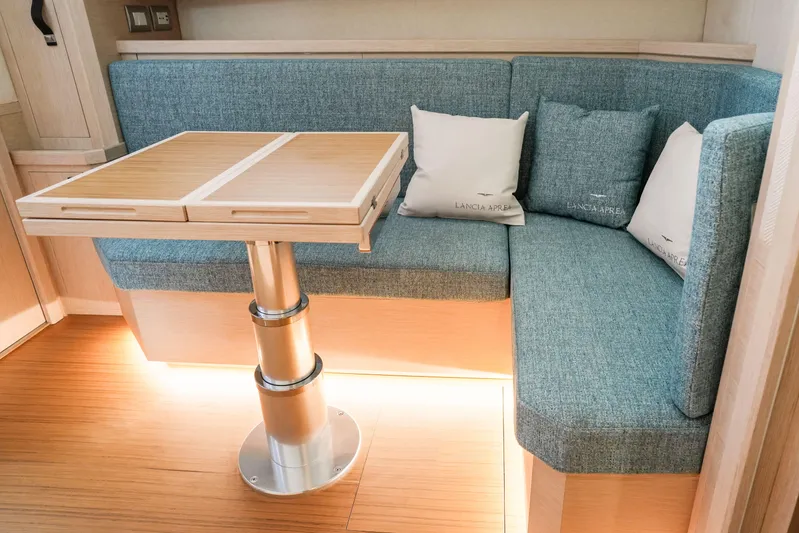 Viviendo Yacht Photos Pics 2024 Lancia Aprea 52 interior with blue seating and wooden table.