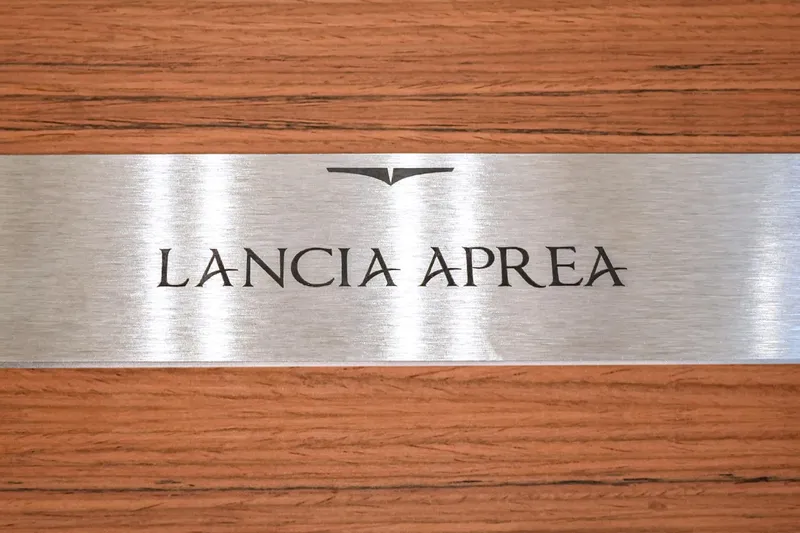 Viviendo Yacht Photos Pics 2024 Lancia Aprea 52 nameplate on wood background, sleek metallic design.