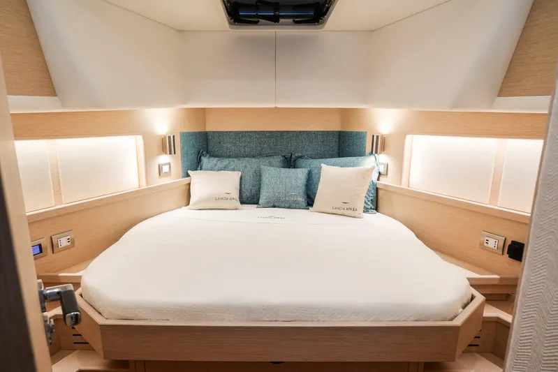 Viviendo Yacht Photos Pics Luxurious interior of 2024 Lancia Aprea 52 yacht with elegant bedding and ambient lighting.