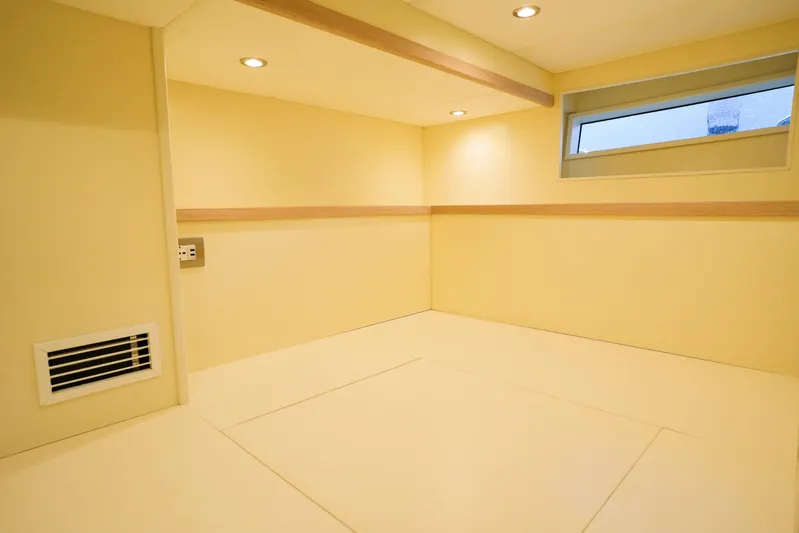 Viviendo Yacht Photos Pics Minimalist interior of 2024 Lancia Aprea 52, featuring recessed lighting and a small window.