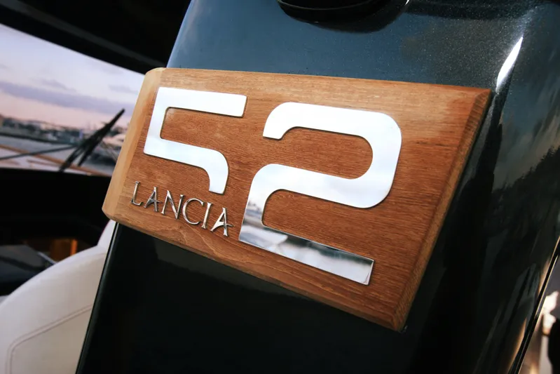 Viviendo Yacht Photos Pics 2024 Lancia Aprea 52 emblem on wooden panel, showcasing sleek design.