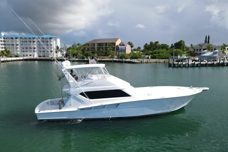 Glomar I Yacht Photos Pics 2004 Hatteras 60 Convertible yacht cruising in a scenic marina setting.