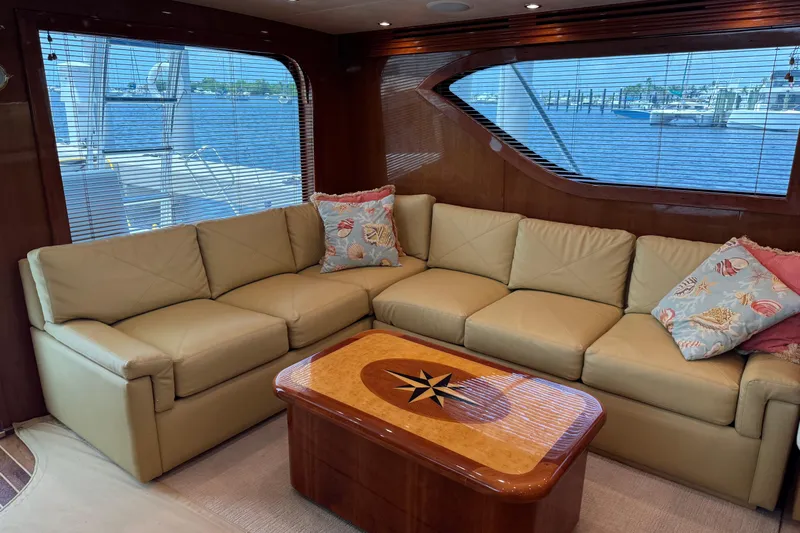 Glomar I Yacht Photos Pics Luxurious interior of 2004 Hatteras 60 Convertible yacht with leather sofa and nautical decor.