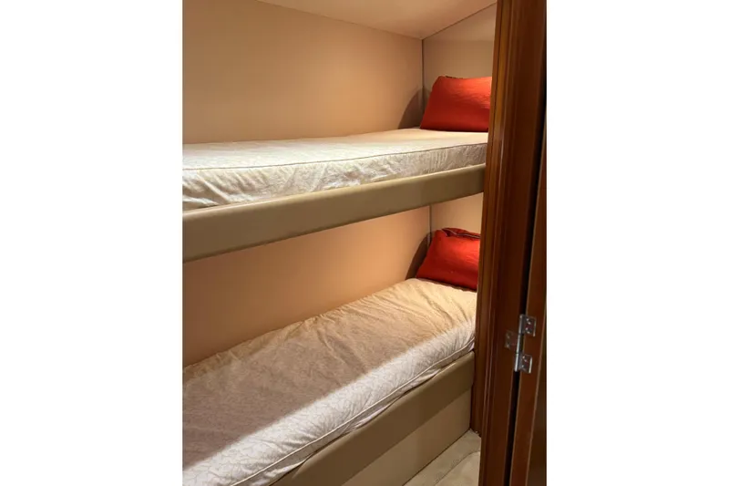 Glomar I Yacht Photos Pics Bunk beds with red pillows in 2004 Hatteras 60 Convertible yacht cabin.