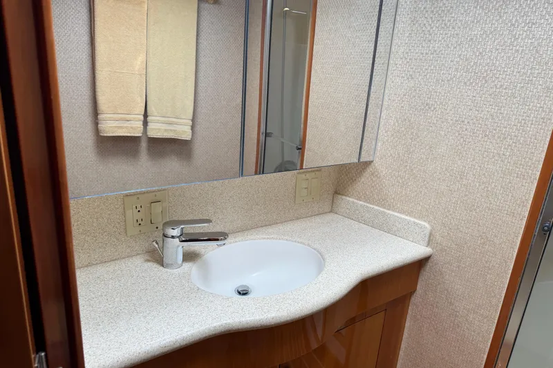 Glomar I Yacht Photos Pics Bathroom vanity in 2004 Hatteras 60 Convertible yacht, featuring a sleek sink and mirror.