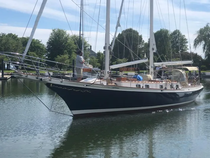 Light Reign Yacht Photos Pics Cherubini Schooner 2000 sailing in calm waters, surrounded by lush greenery.