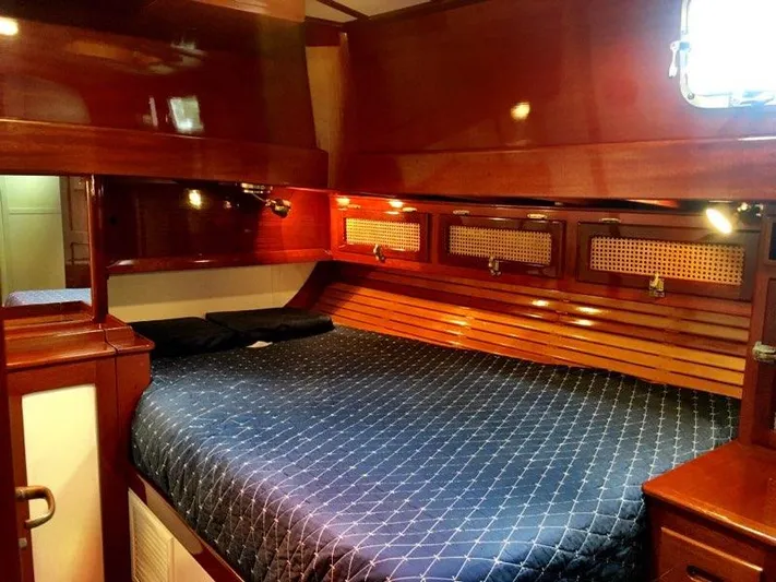 Light Reign Yacht Photos Pics Luxurious cabin interior of 2000 Cherubini Schooner with polished wood and cozy bedding.