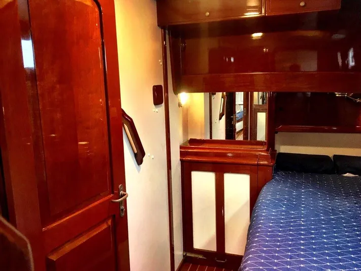 Light Reign Yacht Photos Pics Interior of 2000 Cherubini Schooner with polished wood and cozy bedding.