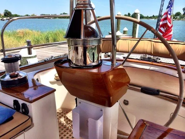 Light Reign Yacht Photos Pics Cockpit of 2000 Cherubini Schooner with polished wood and nautical equipment, docked by the water.
