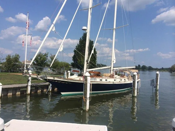 Light Reign Yacht Photos Pics Cherubini Schooner 2000 docked by a scenic waterfront under a blue sky.