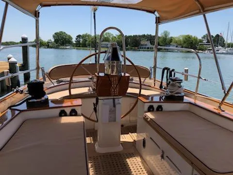 Light Reign Yacht Photos Pics Cherubini Schooner 2000 cockpit with wooden helm, docked by serene waters.